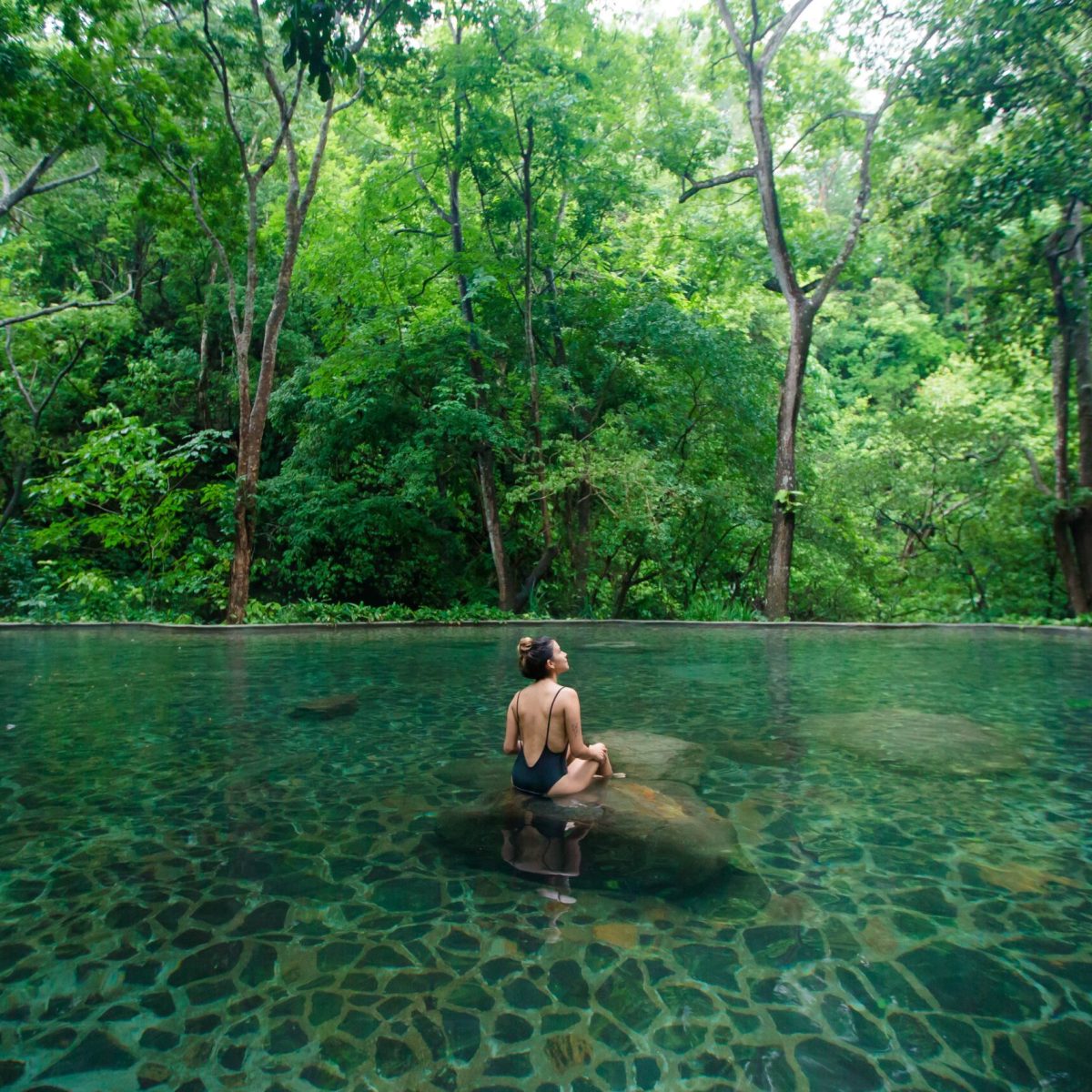 Vandara_15Junio-182-min a women sitting on a rock in a pool