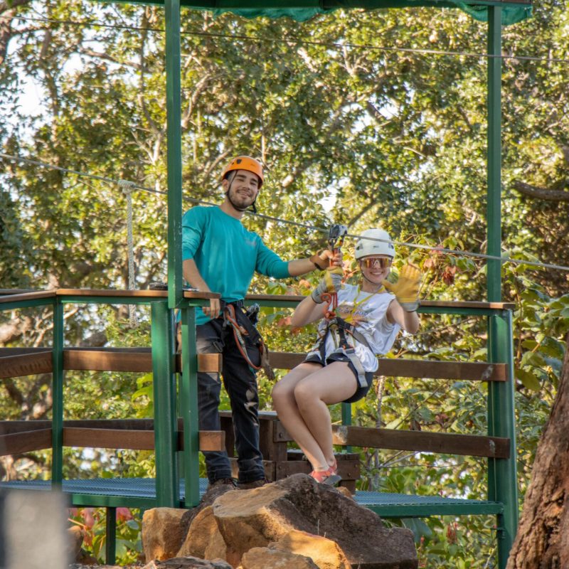 a man and a woman standing in front of a fence