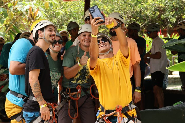Group of people in helmets taking a selfie outdoors.